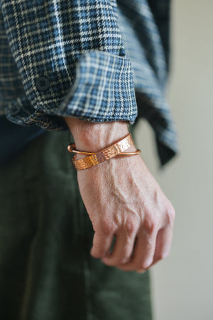 Kopero Copper Bracelet Hammered, on the wrist over a checked shirt sleeve, together with a smooth bracelet
