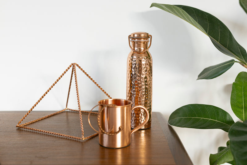Kopero pyramid, water bottle and mug on a light shelf, close-up of the material