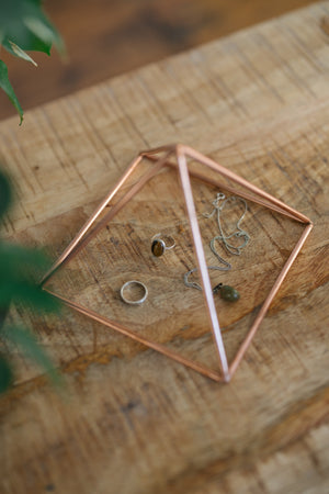 Kopero Copper Pyramid Energizer Smooth Small (14.56 cm), with jewellery underneath on a wooden board