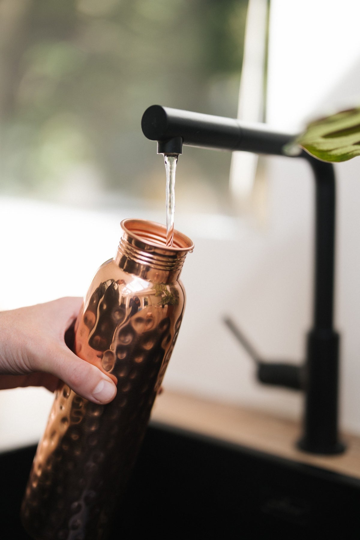 Kopero Copper Water Bottle Hammered, under the tap, while water flows in