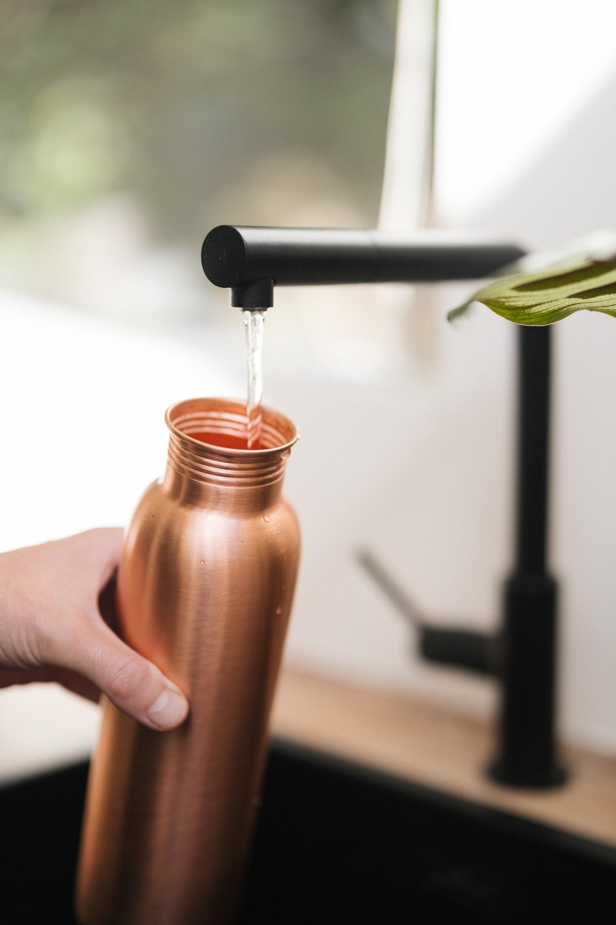 Kopero Copper Water Bottle Smooth, under the tap, while water flows in