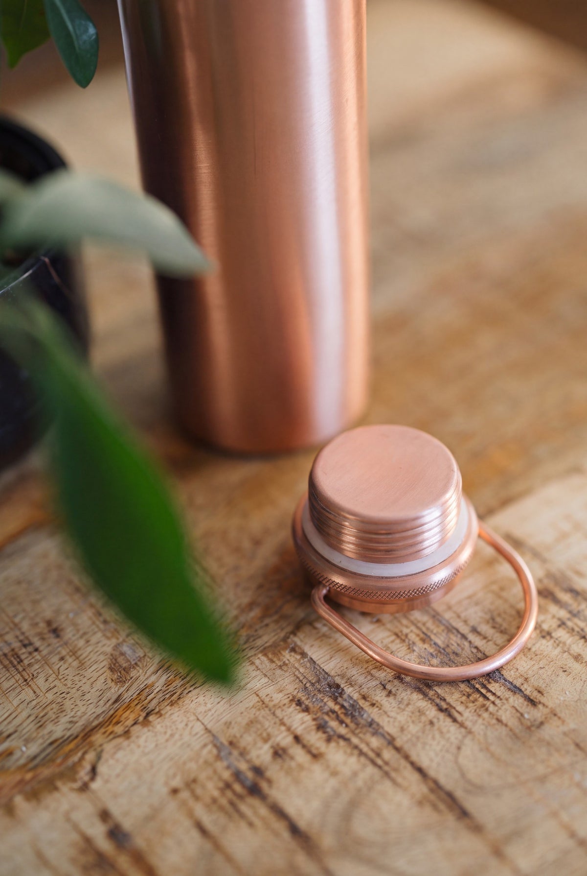 Kopero Copper Water Bottle Smooth, close-up of the loose cap with turning handle on a wooden table